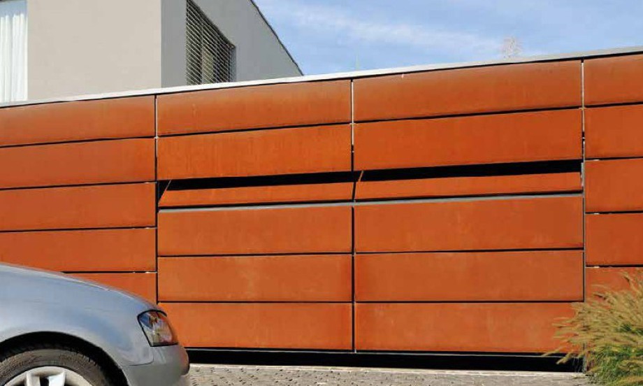 ein in die Fassade eingelassenes Garagentor öffnet sich und man erkennt erst das ein Tor in der Wand ist