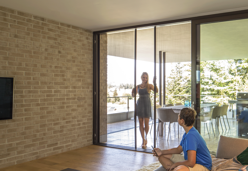 Person betritt durch ein Insektenschutzplisee ein Zimmer