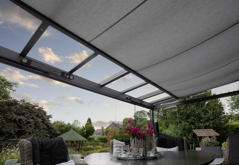 Unterdachmarkise fährt aus und beschattet eine Sitzgruppe auf einer Terrasse